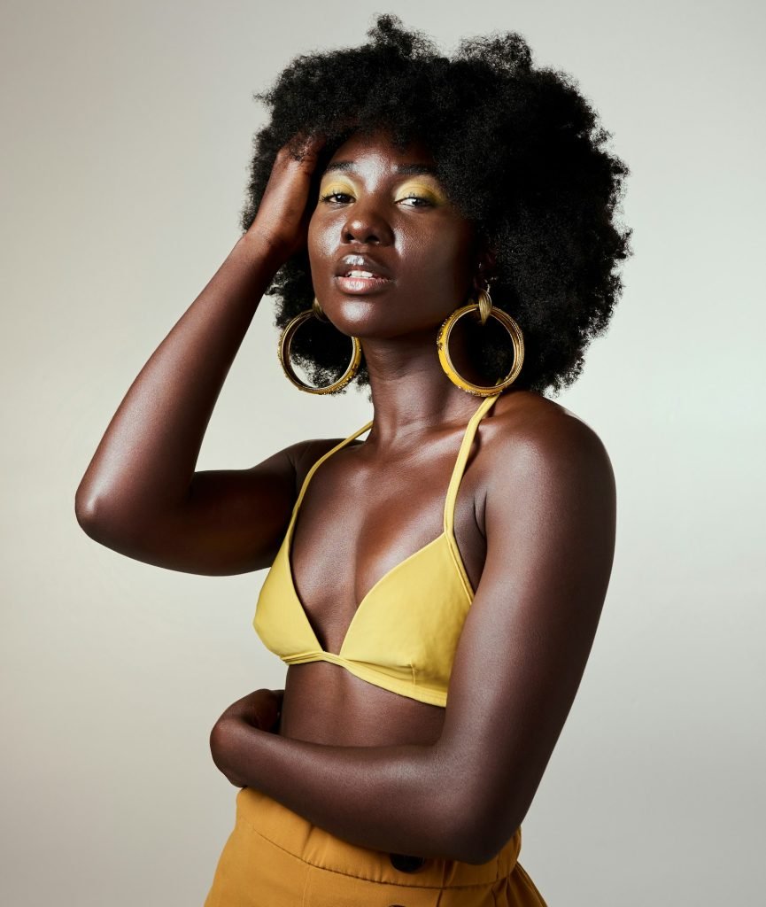 Black woman, beauty and fashion, makeup or hair care and gold jewelry on gray studio background. Po